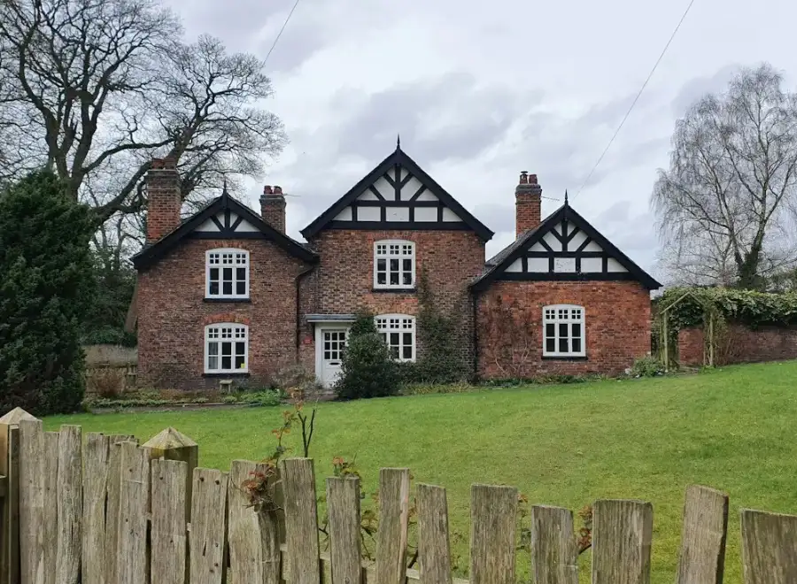 Brick houses with mock-Tudor gables behind a wooden fence